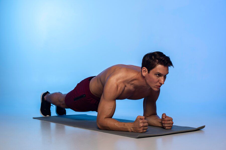 Man in plank position with straight arms and engaged core.